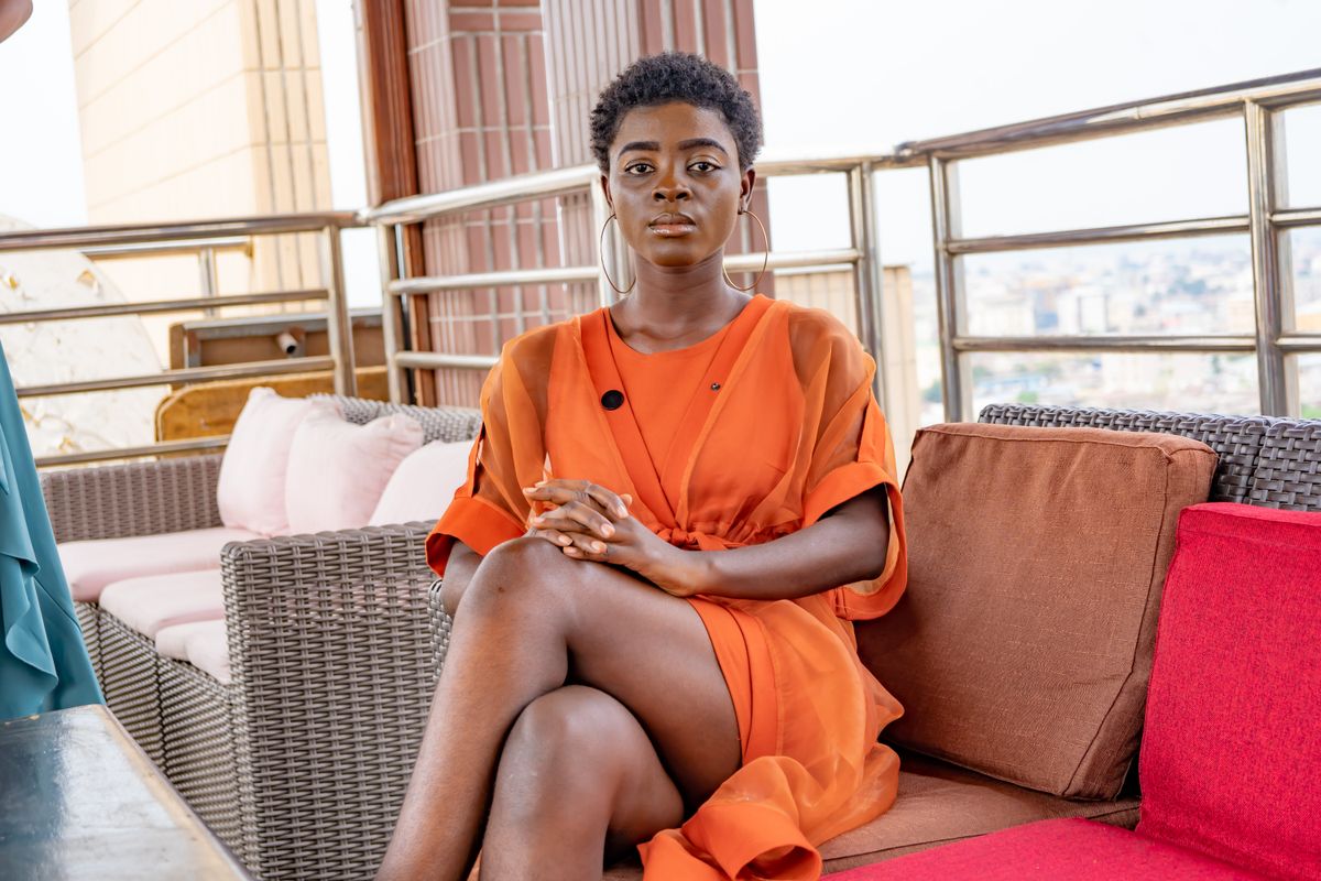 Une femme en robe orange sur une terrasse de Brazzaville